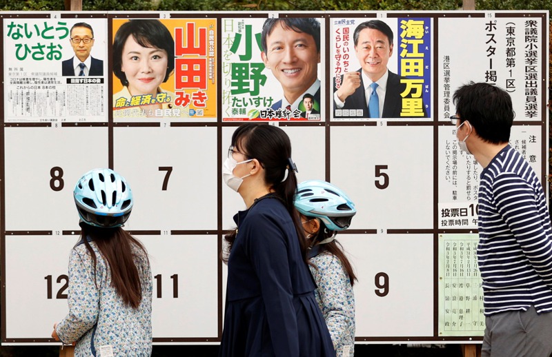 日本新任眾議員當選後10月僅在職1天就可領取當月全額的文通費100萬日圓，引發爭議。圖為民眾觀看眾議員候選人海報。路透