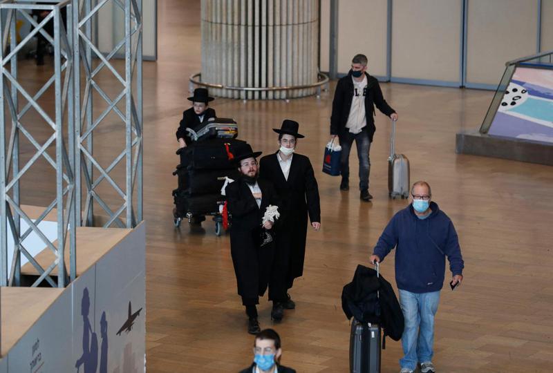 旅客廿八日抵達以色列特拉維夫近郊的班古里昂機場。以色列宣布禁止所有外國人入境，本國人返國也必須隔離。（法新社）