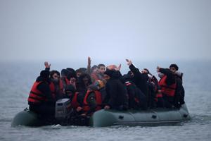 40多名難民24日擠在一艘充氣艇上，離開法國加萊附近的維姆勒鎮沿岸前往英國。 路透