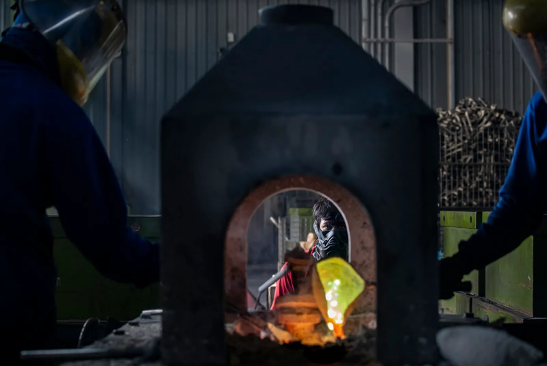 彰化水五金廠，印尼移工把900℃的銅液，舀進水龍頭模具上成形。因為現場太熱，要三人輪流作業。 圖片來源：謝佩穎攝