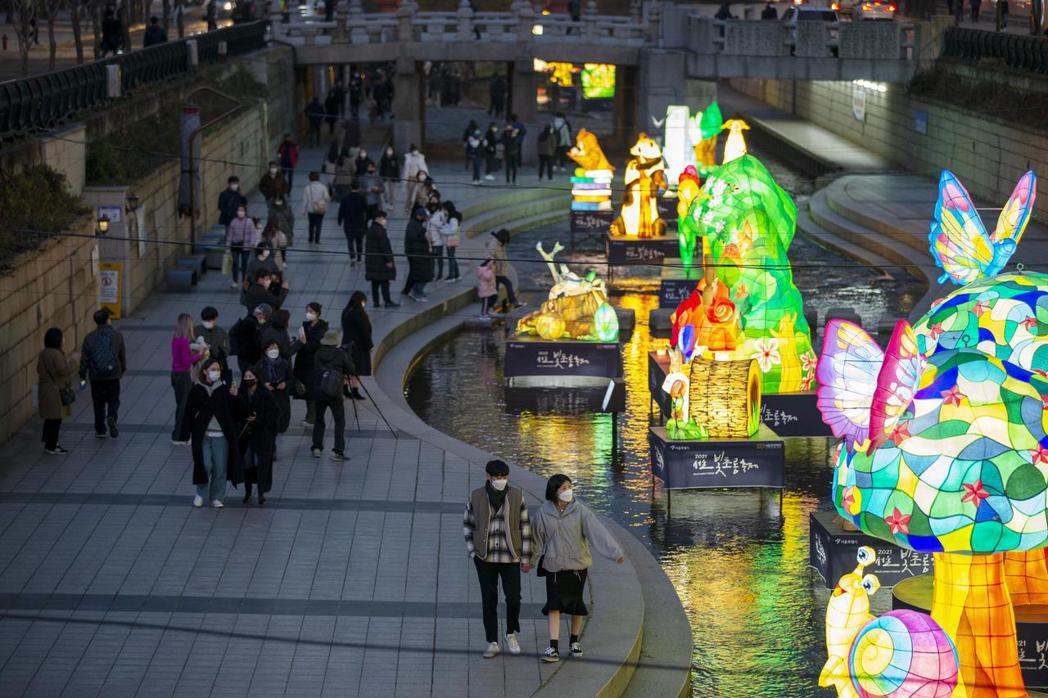 南韓首爾民眾上月29日經過當地清溪川觀賞花燈節展出的花燈。新華社