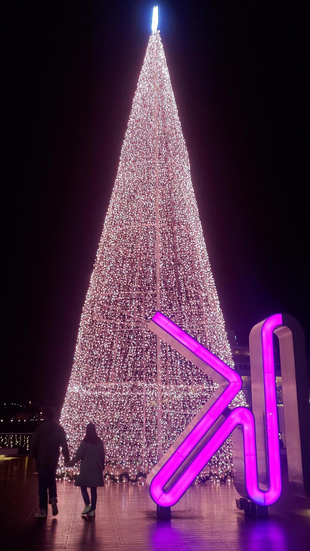 基隆晚間點亮17米耶誕燈塔，照亮港邊夜空民眾拍光雕美。圖／基隆市政府提供
