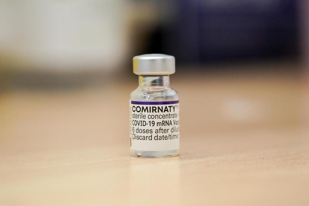 倫敦接種站桌上4日擺放一瓶尚未使用的輝瑞疫苗。（美聯社）