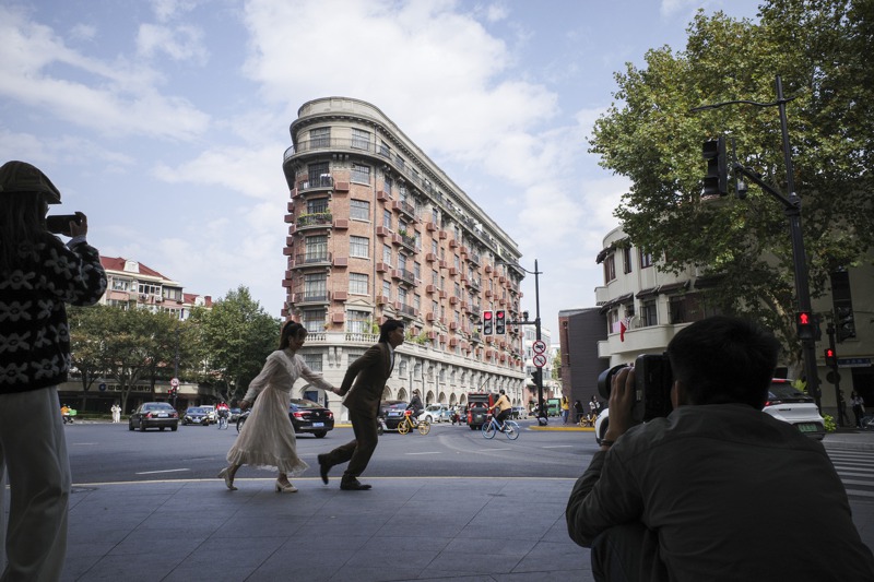 上海武康大樓周遭經常有人拿著「長槍短砲」來此拍攝這知名的網紅建築。新華社