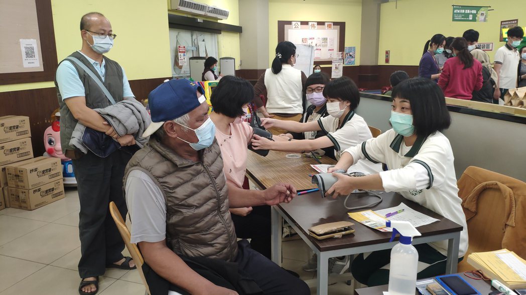 樹人醫專學生為施打疫苗民眾量血壓。記者謝進盛／攝影