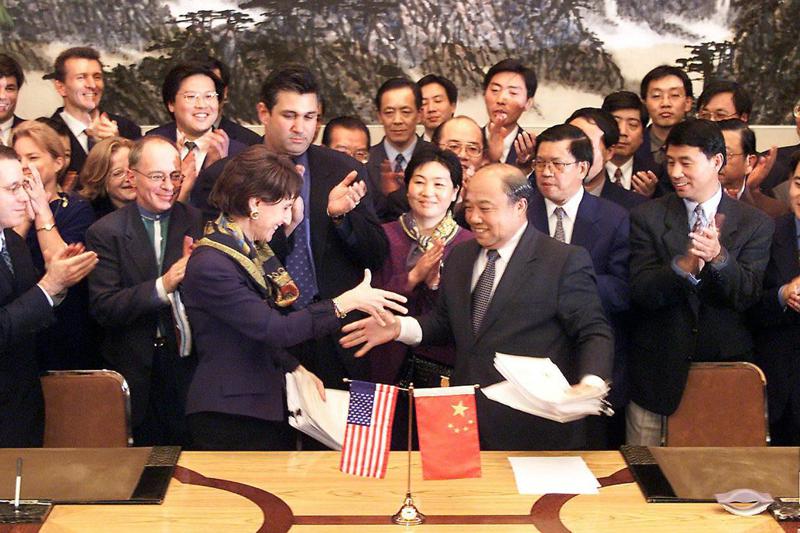 美中兩國在1999年11月15日於北京簽訂入世協議後，美國貿易代表白茜芙（左前）與大陸對外貿易經濟合作部部長石廣生（右）握手。法新社