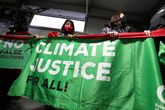 人們在COP26氣候峰會期間，於會場附近舉著「氣候正義」的橫幅。 路透社