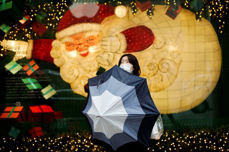 儘管日本政府一直試圖引發通貨膨脹，但消費者物價指數始終低迷不振。圖為東京街頭一名女子站在聖誕燈飾前。 路透社