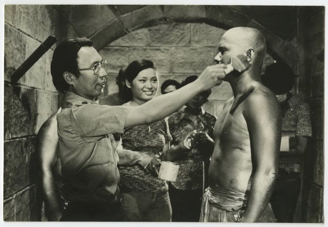 導演郭南宏（左）執導「少林寺十八銅人」時，親自為扮成銅人的演員塗上金漆。 圖／國家電影及視聽文化中心