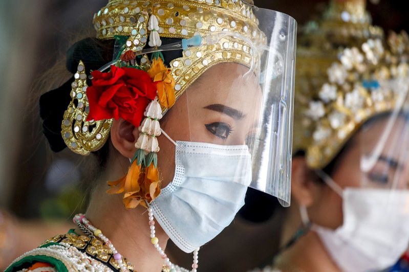 疫情再起迫使泰國政府重新思考觀光策略，圖為泰國的印度教舞者戴口罩表演。歐新社