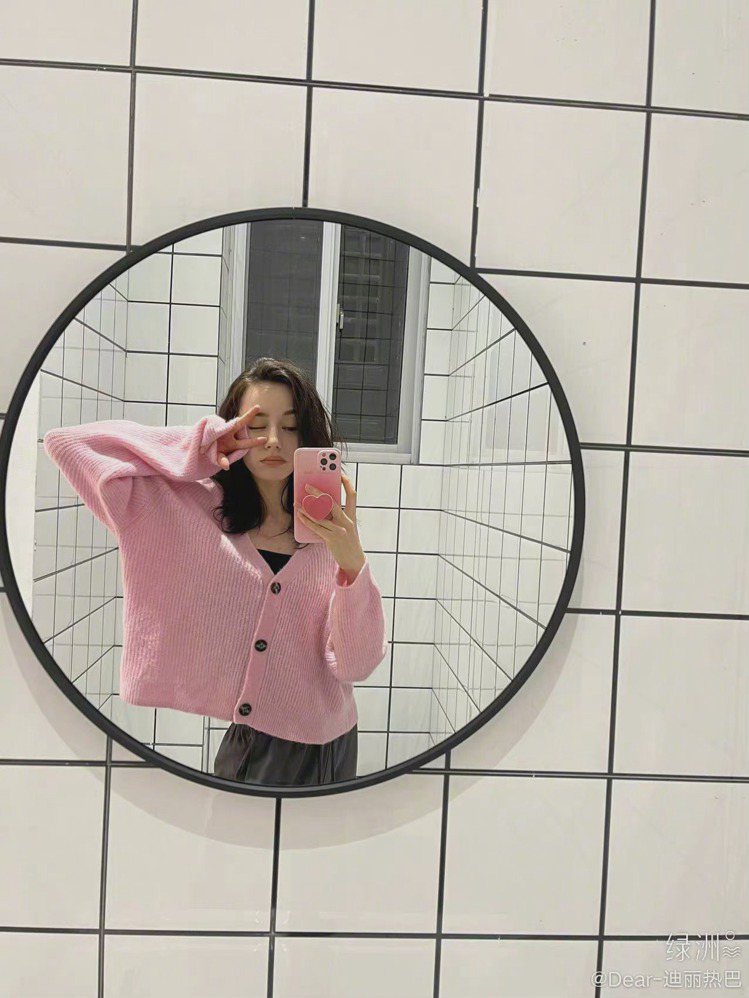 迪麗熱巴身穿粉紅色寬版針織衫，來自丹麥品牌GANNI。圖／取自微博