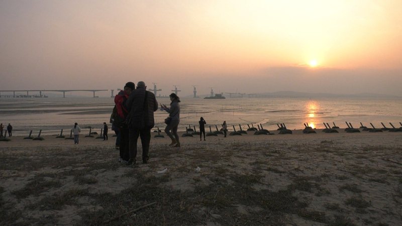 為了欣賞金門最後一道夕陽，不少台灣的遊客到慈堤追日。記者蔡家蓁／攝影