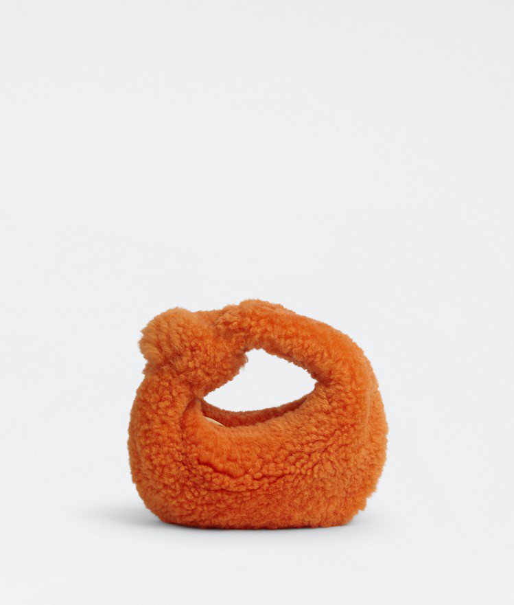 Mini Jodie毛絨繩結手提包 (蜜橙橘) ，77,800元。圖／BOTTEGA VENETA提供