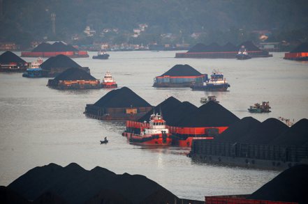 印尼今年元旦緊急暫停煤炭出口，圖為印尼煤產區沙馬林達，裝煤的駁船在河上被拖船牽引前進。 路透