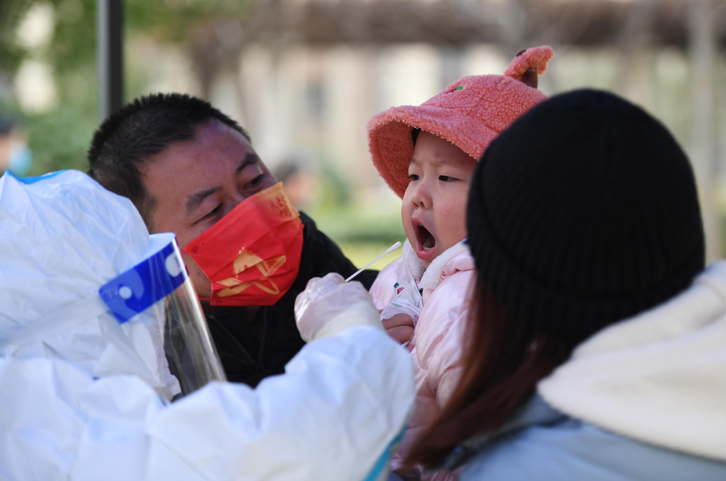 圖為河南鄭州一名幼童日前接受核酸檢測採樣。新華社