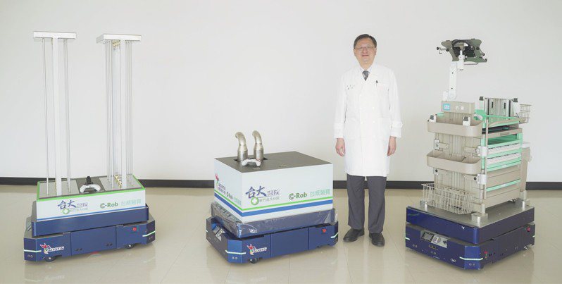 新竹臺大分院院長余忠仁與「C-Rob 智慧自主移動機器人」合影，（由左至右）3台機器人功能分別是紫外線殺菌、噴霧殺菌以及護理工作車。圖／新竹臺大分院提供