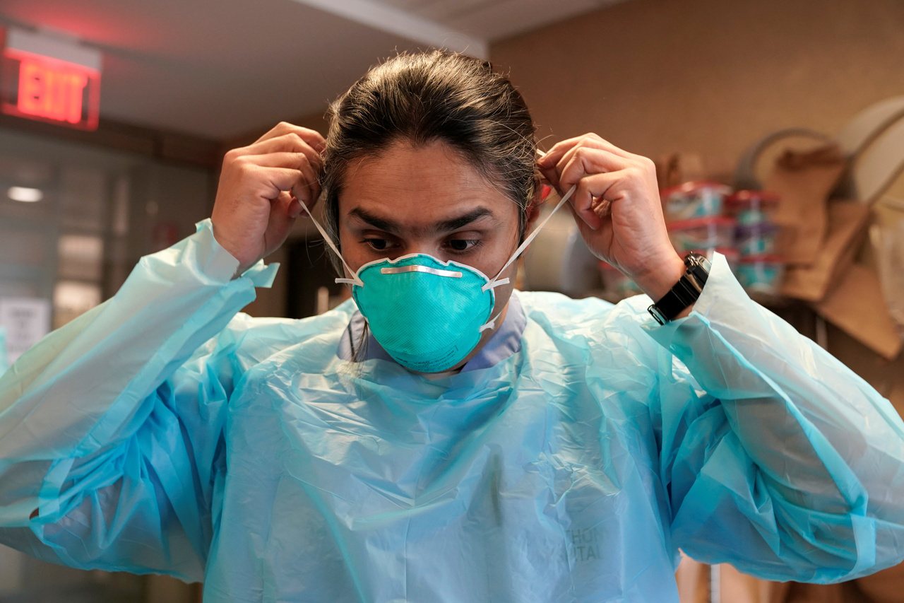 美國奧克拉荷馬州Syed Naqvi醫師在進入加護病房照顧新冠患者之前，戴上N95口罩。  路透