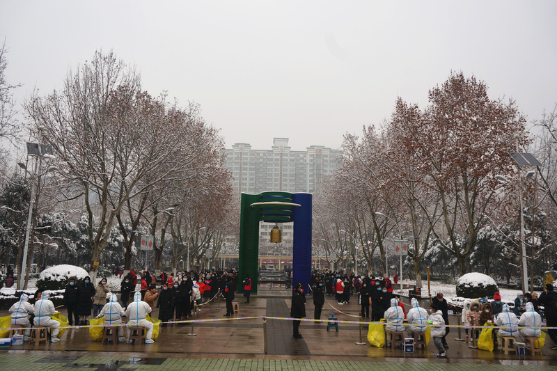 河南新冠疫情近日快速升溫，鄭州市民冒著風雪接受核酸檢測。中新社