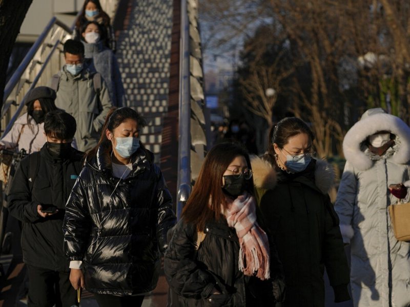 北京民眾外出時戴上口罩防疫。（美聯社）