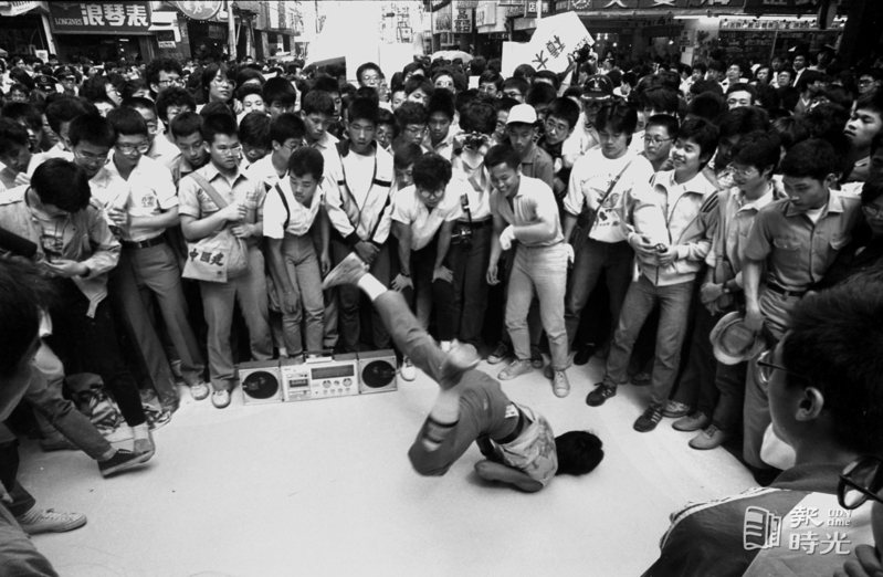為西門鬧區設徒步區舉辦的街頭藝術表演，九日許多的霹靂舞者和民眾帶著簡易的收音錄音機伴奏就跳了起來，使得獅子林廣場一帶摩肩接踵。日期：1985/6/9．攝影：本報記者．來源：聯合報