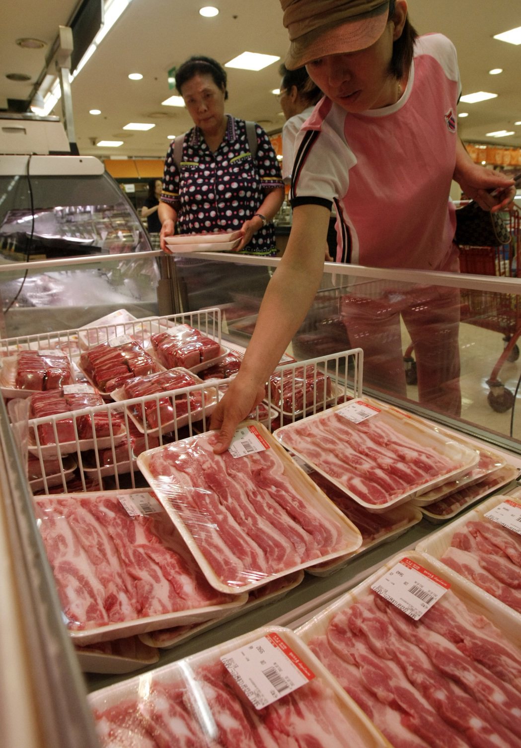 首爾一間超市的消費者挑選豬肉。（美聯社）