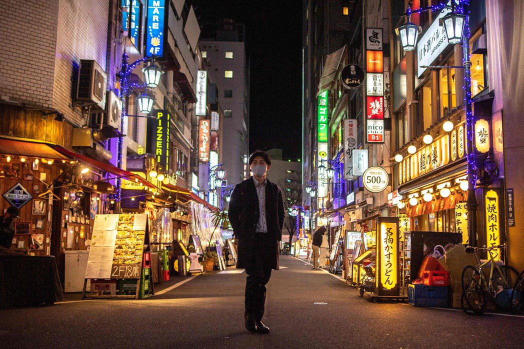 日本東京一名男子21日經過新宿街頭。法新社