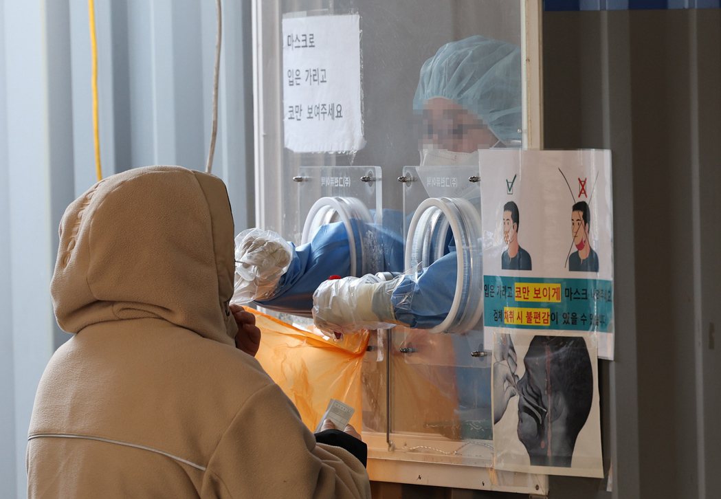 南韓將改變防疫策略圍堵Omicron，圖為23日民眾在首爾一處臨時病毒檢測站接受...