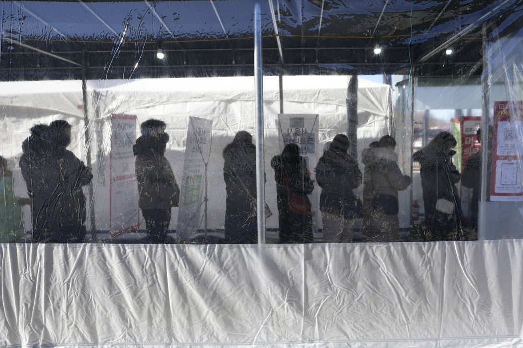 南韓首爾民眾去年12月31日在當地篩檢站排隊準備接受新冠肺炎檢測。美聯社