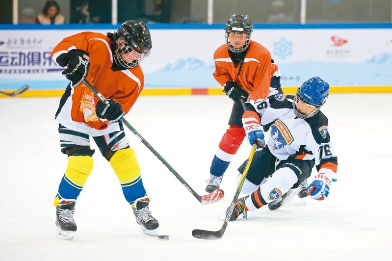 1月25日，南京首屆青少年冰球聯賽火熱開賽，掀起冰雪運動熱。圖為參賽球員在比賽中競技。（中新社）