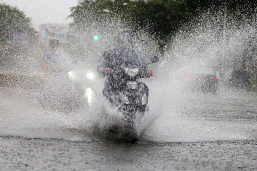 汽機車在雨水行經積水路段需減速慢行，否則濺濕他人可能會挨罰。 聯合報系資料照／記者劉學聖攝影
