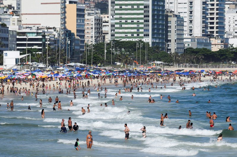 Omicron肆虐，巴西各地首府已宣布取消或延後舉行今年的嘉年華。圖為25日里約熱內盧沙灘戲水人潮。 路透社