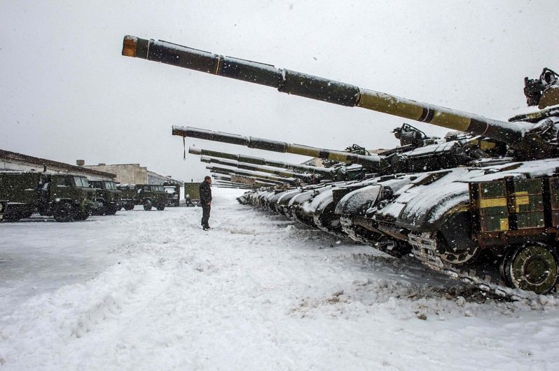乌克兰武装部队一名军人站在第92独立机械化旅位于哈尔科夫地区基地的战车队前方，摄于1月31日。美国白宫表示，将不再使用「迫在眉睫」叙述俄罗斯「入侵」乌克兰相关状况时。法新社(photo:UDN)
