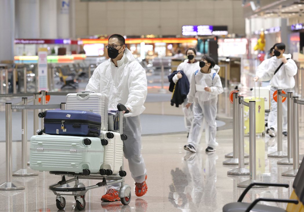 為降低染疫風險，入境旅客穿著防護衣。 圖／聯合報系資料照片