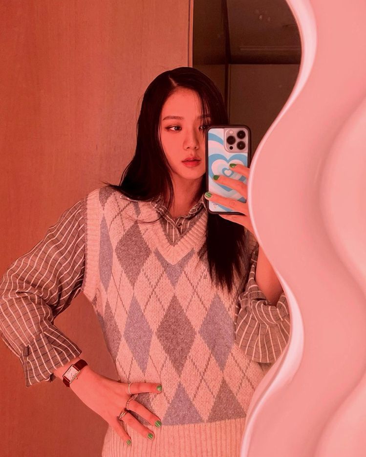 Jisoo在波浪鏡前的最新照片，穿了韓國品牌Common Unique的菱格紋背心，搭配Cartier表款、戒指，展現Wild Flower手機殼。圖／取自IG