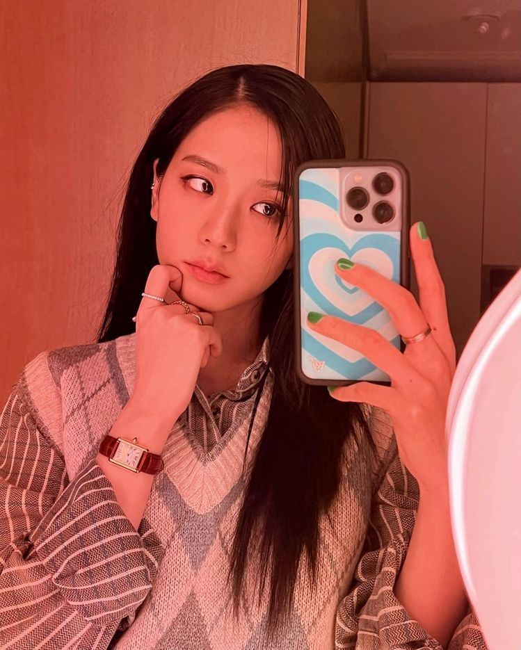 Jisoo在波浪鏡前的最新照片，穿了韓國品牌Common Unique的菱格紋背心，搭配Cartier表款、戒指，展現Wild Flower手機殼。圖／取自IG