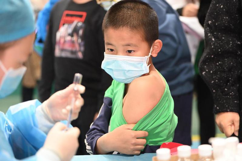 專家指出，等到下半年國境開放，未打疫苗的兒童可能成為社區感染的高危險群。圖為內蒙古兒童等待接種新冠病毒疫苗。中新社