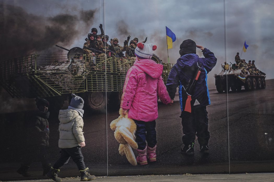 盧干斯克前線區、一名烏克蘭小男孩走過烏軍控制範圍內的愛國壁畫。 圖／美聯社