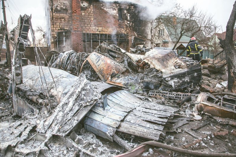 飛機墜基輔 一名烏克蘭消防員在首都基輔一個墜機現場查看。（美聯社）