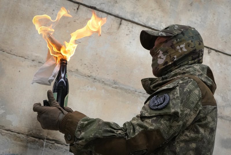 乌克兰人25日蜂拥上Google搜寻如何自制「莫洛托夫鸡尾酒」（Molotov Cocktails），也就是汽油弹。图为基辅居民在训练营学习使用汽油弹。美联社(photo:UDN)