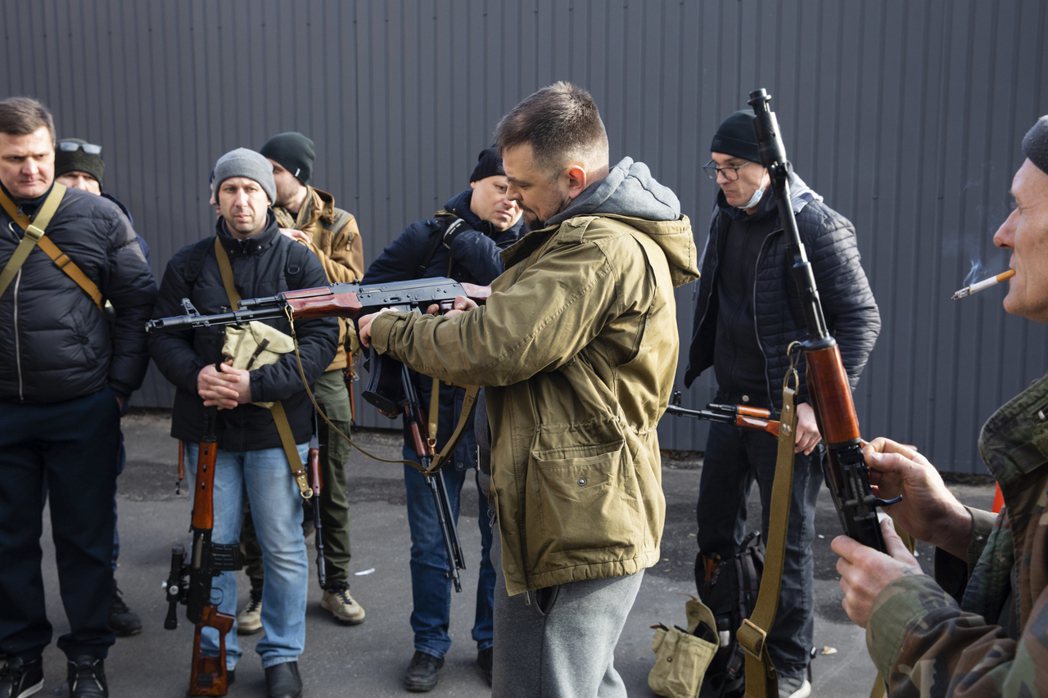 烏克蘭遭俄羅斯入侵後，基輔及烏克蘭東部戰場前線的多城「全民皆兵」，幾乎所有成年烏克蘭人都獲配武器，誓死捍衛家園。圖為基輔市居民領到槍枝後試用。 圖／美聯社