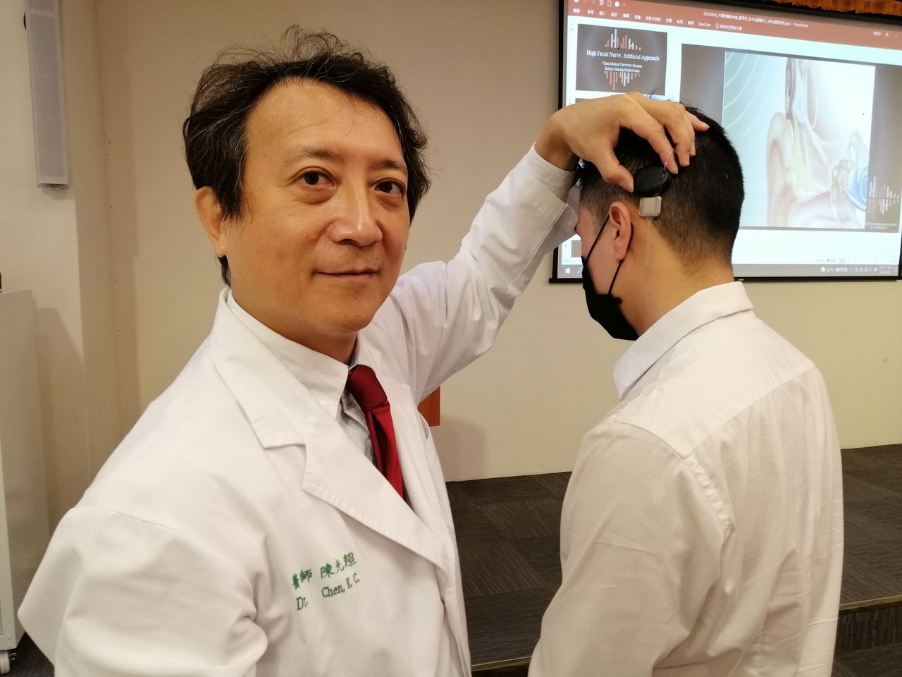 醫師陳光超（左）說明，人工耳蝸是重度聽力損失（聽力損失大於70分貝）的治療首選。圖／中國附醫提供