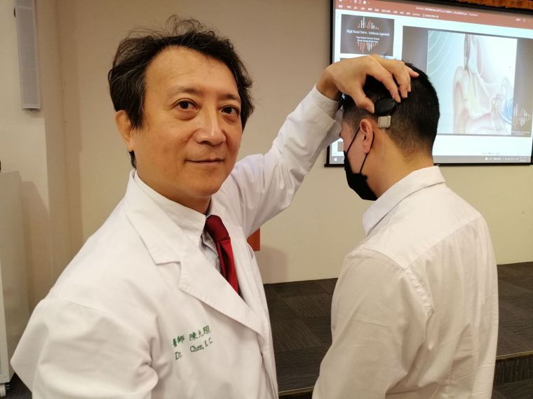 醫師陳光超（左）說明，人工耳蝸是重度聽力損失（聽力損失大於70分貝）的治療首選。...
