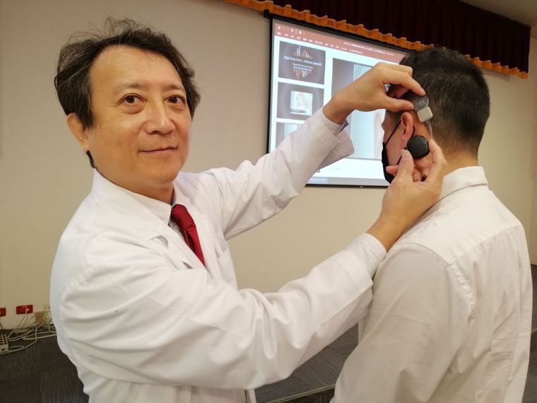 醫師陳光超（左）說明，人工耳蝸是重度聽力損失（聽力損失大於70分貝）的治療首選。...