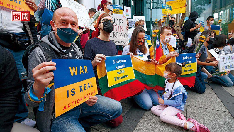 烏克蘭爆發戰事，在台外國人與台灣民眾於台北街頭發起聲援行動，他們舉著「台灣與烏克蘭站在一起」的牌示，呼籲停止戰爭。 (攝影者：駱裕隆)