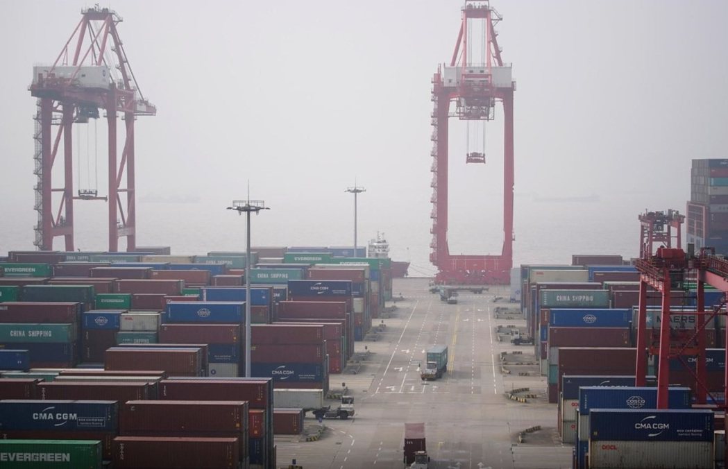 貨車在上海洋山港的貨櫃之間穿行。路透