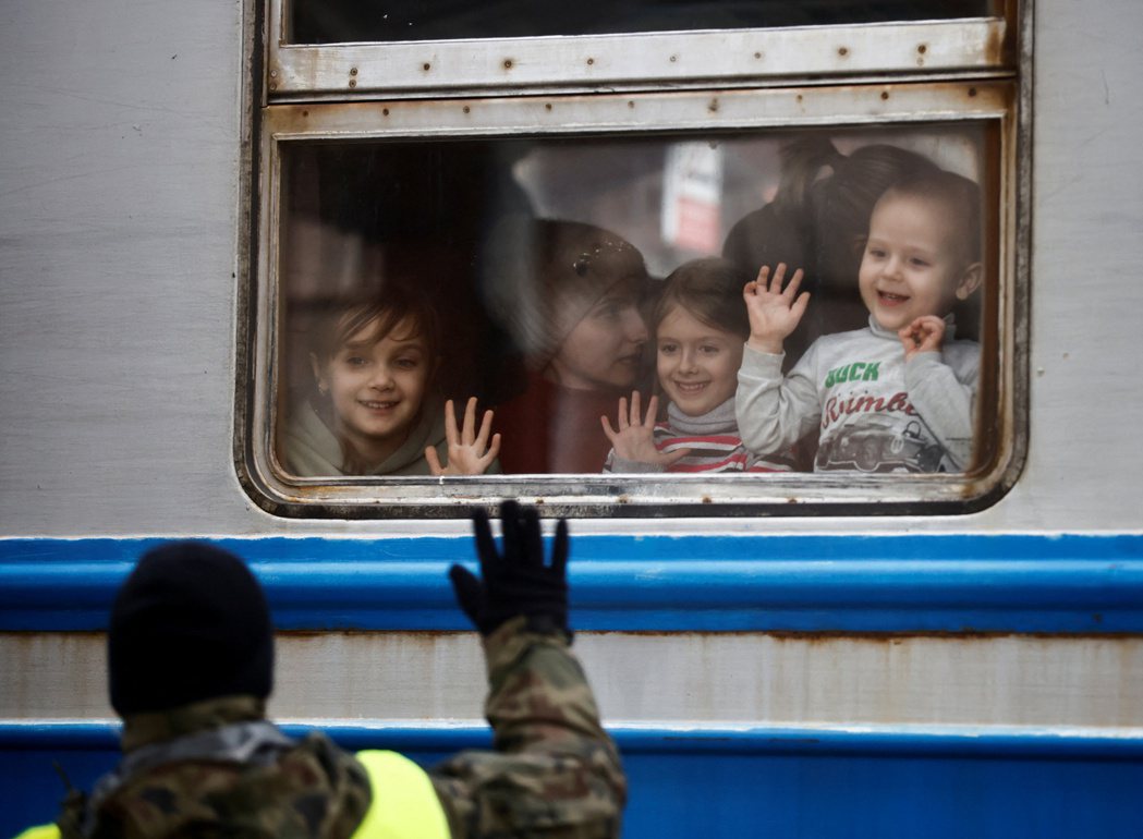 波蘭軍隊在車站向抵達的烏克蘭疏散火車揮手。 圖／路透社