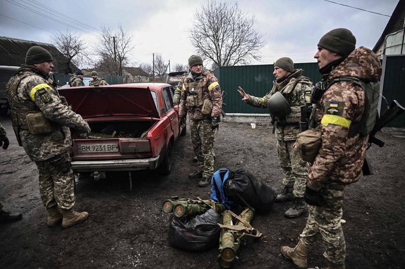 專家分析，烏克蘭現在的戰略是把保衛重點放在地面，盡量減少大型編隊行動，讓俄羅斯難集中兵力。圖為3日烏克蘭首都基輔東北的烏軍士兵正從一輛舊車的後車廂卸下武器。法新社