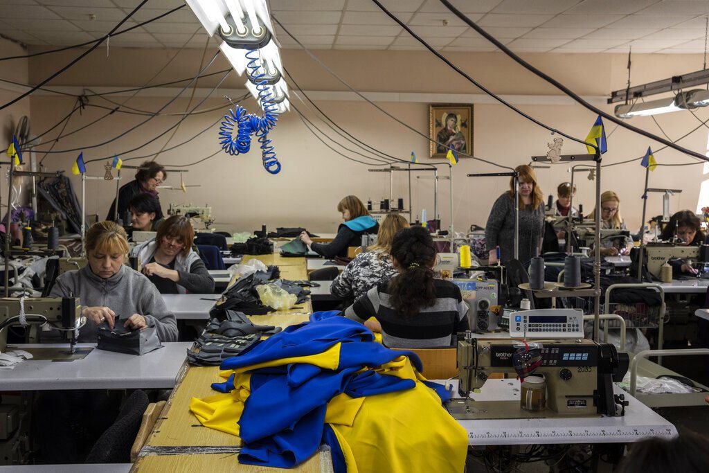 烏克蘭志願民眾在烏克蘭西部利沃夫縫製烏克蘭國旗和急救箱。 圖／美聯社