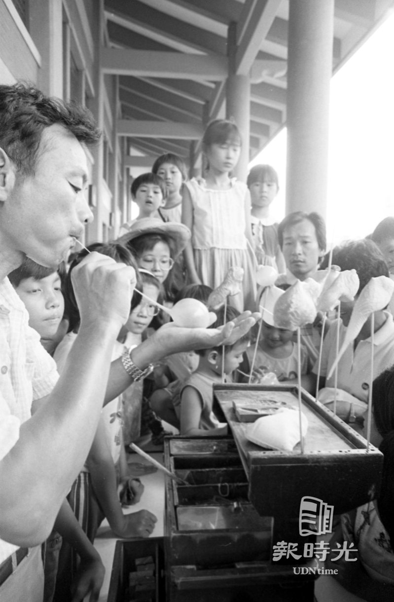 台北市假日表演廣場，十三日在國父紀念館舉行陀螺、扯鈴、紙雕、吹糖、捏麵人、書法等一系列的民俗技藝表演，吸引不少民眾前往觀賞。日期：1985/07/13．攝影：陳曙光．來源：聯合報