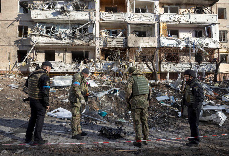 烏克蘭士兵15日檢視基輔一處遭砲擊公寓大廈的斷垣殘壁。法新社